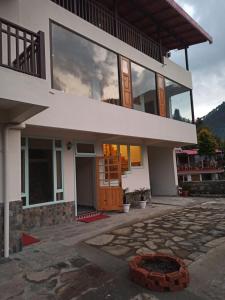 a house with a large window and a patio at Kainchi Boutique Homestay in Rāmgarh