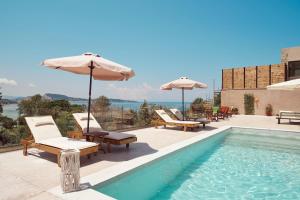 een zwembad met stoelen en parasols naast een zwembad bij Villa Vicky in Zakynthos