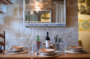 una mesa con una botella de vino y copas. en Casa nei Fiori di Lecce, en Lecce