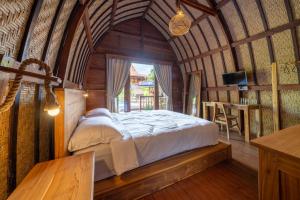 um quarto com uma cama num quarto com uma janela em Lumbung Sari em Uluwatu