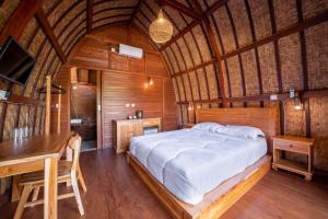 a bedroom with a bed and a desk in a room at Lumbung Sari in Uluwatu
