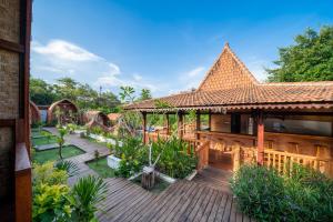 a house with a wooden deck and a building at Lumbung Sari in Uluwatu