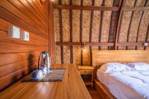 a bedroom with a bed and a table with a coffee maker at Lumbung Sari in Uluwatu