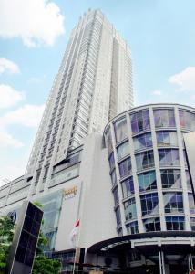 un edificio blanco alto con una bandera delante de él en HARRIS Suites fx Sudirman, en Yakarta