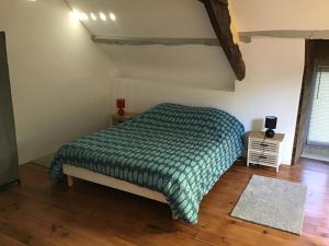 una camera da letto con un letto con un piumone verde di Coucou cottage a Saint-Congard