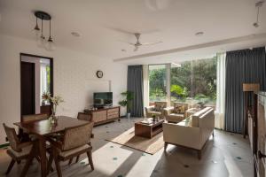 a living room with a table and chairs at El Arbol by The Blue Kite with Rooftop Pool, Kitchen, Wifi, Security,10 Mins to Candolim Beach & 5 mins to Casino in Panaji +192 photos