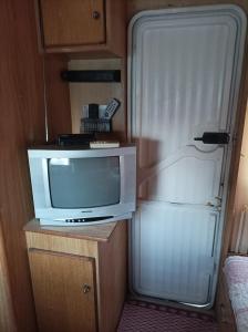 a kitchen with a refrigerator and a tv at Camping Little Oasis in Ezerets