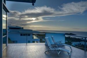 two chairs on a balcony with a view of the ocean at Happy Days Villa C in Fajardo