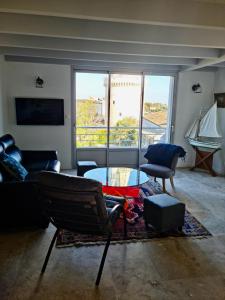 Una sala de estar con un sofá y una mesa de cristal. en Duplex vue sur tour Appartement Remparts 3, en La Rochelle