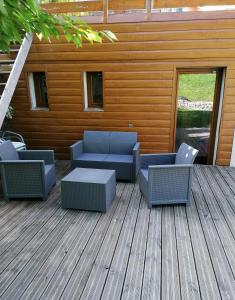 una terraza con sofás y sillas en un edificio en Le grand duc en Mijoux