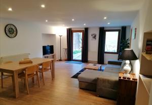 a living room with a table and a couch at Le grand duc in Mijoux