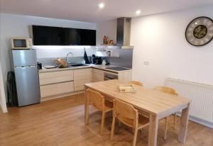 a kitchen with a table with chairs and a refrigerator at Le grand duc in Mijoux