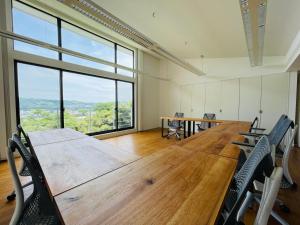 una sala conferenze con tavolo, sedie e una grande finestra di 伊東温泉 Working Base Izu-Ito a Ito