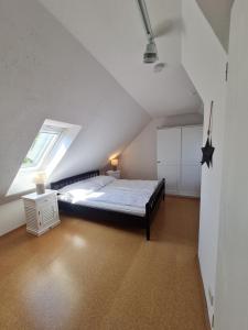 1 dormitorio en el ático con cama y ventana en Saltwater Happy, en Büsum