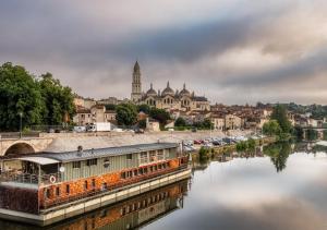 ein Fluss mit einer Stadt im Hintergrund in der Unterkunft The Originals City, Hôtel Régina, Périgueux in Périgueux