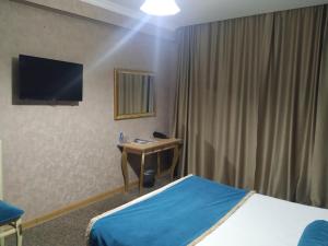 a hotel room with a bed and a desk and a television at Gallery Hotel Baku in Baku