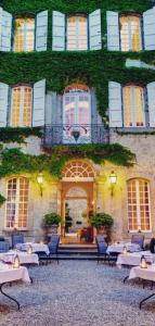 um edifício com mesas e cadeiras em frente em Chambres d'hôtes Relais Mira Peis em Mirepoix