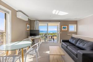 sala de estar con sofá y mesa en Aqualuna Beach Resort, en Coffs Harbour