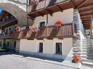 ein Gebäude mit einem Balkon mit Blumen darauf in der Unterkunft LO PONTON cir 0022 in Introd