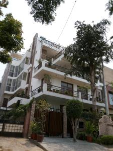 a white building with a fence in front of it at Sovereign Residency in Noida