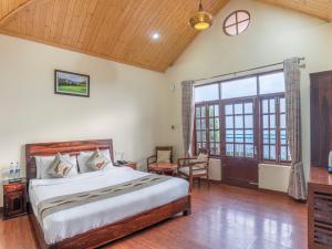 a bedroom with a bed and a large window at Echor - The Koti Village Resort Kufri in Kūfrī