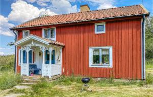 a red house with a grill in front of it at Awesome Home In Skillingaryd With 2 Bedrooms in Skillingaryd
