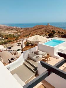 a villa with a swimming pool on a hill at White Curves Santorini in Akrotiri