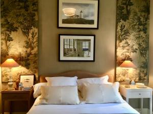 ドラギニャンにあるVilla Côté Sudのベッドルーム1室(ベッド1台付)が備わります。壁に2枚の写真が飾られています。