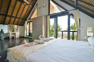 - une chambre avec un grand lit et des serviettes dans l'établissement Villa Altamera, à Umeanyar