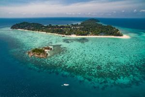 an island in the ocean with a boat in the water at Lipe BeachHouse in Ko Lipe