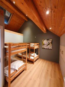2 stapelbedden in een kamer met houten plafonds bij Gite Li School in Custinne
