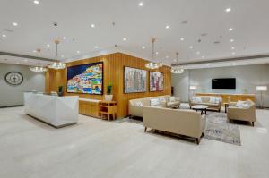 a large living room with couches and a flat screen tv at The Fern Residency Turbhe in Navi Mumbai