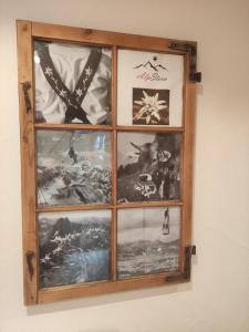 uma janela de madeira com fotografias na parede em AlpStern Ferienwohnung em Oberstdorf