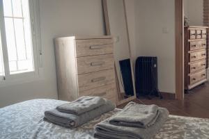 1 dormitorio con tocador y 2 toallas en una cama en Apartamento Doña Lola, en Jerez de la Frontera