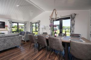 a dining room with a table and chairs at Juniper Lodge, 28 Roadford Lake Lodges in Lifton