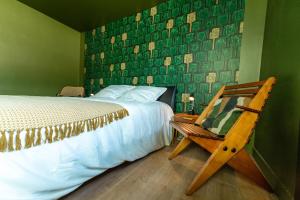 a bedroom with a bed and a wooden chair at Chambre d'hôte près Bordeaux au château Camponac in Bourg-sur-Gironde