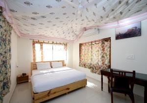 a bedroom with a bed and a desk and a ceiling at The Sky Imperial Kumbhalmer Resorts in Kumbhalgarh