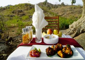 una mesa con un plato de comida en una mesa en The Sky Imperial Kumbhalmer Resorts, en Kumbhalgarh