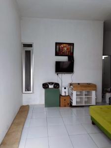 salon z białą podłogą i telewizorem w obiekcie Homestay Srikandi w mieście Garut
