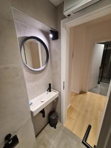 een badkamer met een wastafel en een spiegel bij Romantic New Superior apartments close to Sandy and pebble beach in Crikvenica