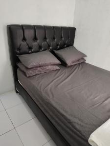 uma cama preta com duas almofadas em Homestay Srikandi em Garut