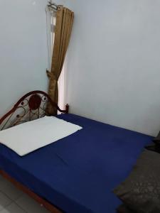 Łóżko lub łóżka w pokoju w obiekcie Homestay Srikandi
