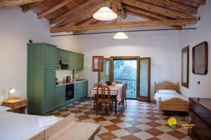 a kitchen with green cabinets and a table in a room at La Via Antiga in Cittànova