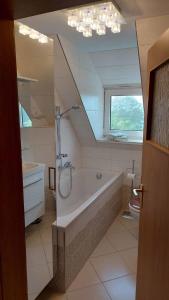 a bathroom with a tub and a sink and a mirror at Ferienhaus am großen Waldstein in Zell im Fichtelgebirge