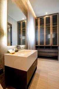łazienka z umywalką i dużym lustrem w obiekcie Grand Villano w mieście Pattaya Central