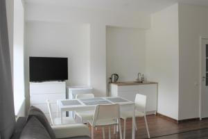 a living room with a table and white chairs at Jūros takas in Juodkrantė