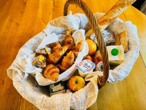 a basket of pastries and apples on a table at Le Manoir des Doyens Loft - Sleeps 8 - Breakfast Included! in Bayeux