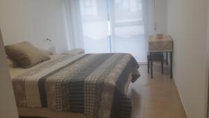 アーレスにあるAgradable apartamento a 2 minutos de la playaのベッドルーム1室(テーブル、ベッド1台付)