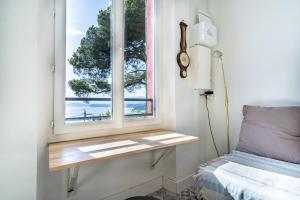 een slaapkamer met een raam met een bed en een vensterbank bij Breathtaking view house with large garden - Dodo et Tartine in Le Pradet