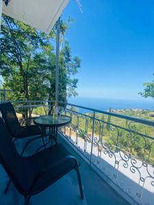 a balcony with a table and chairs and the ocean at Exanthia Sunset in Exanthia